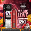 A promotional graphic for the Crown Bar Al Fakher Magic Love Crystal V2 vape device and its packaging. The device is a metallic pink-red color with a patterned design and a clear mouthpiece, shown alongside its black and white box.